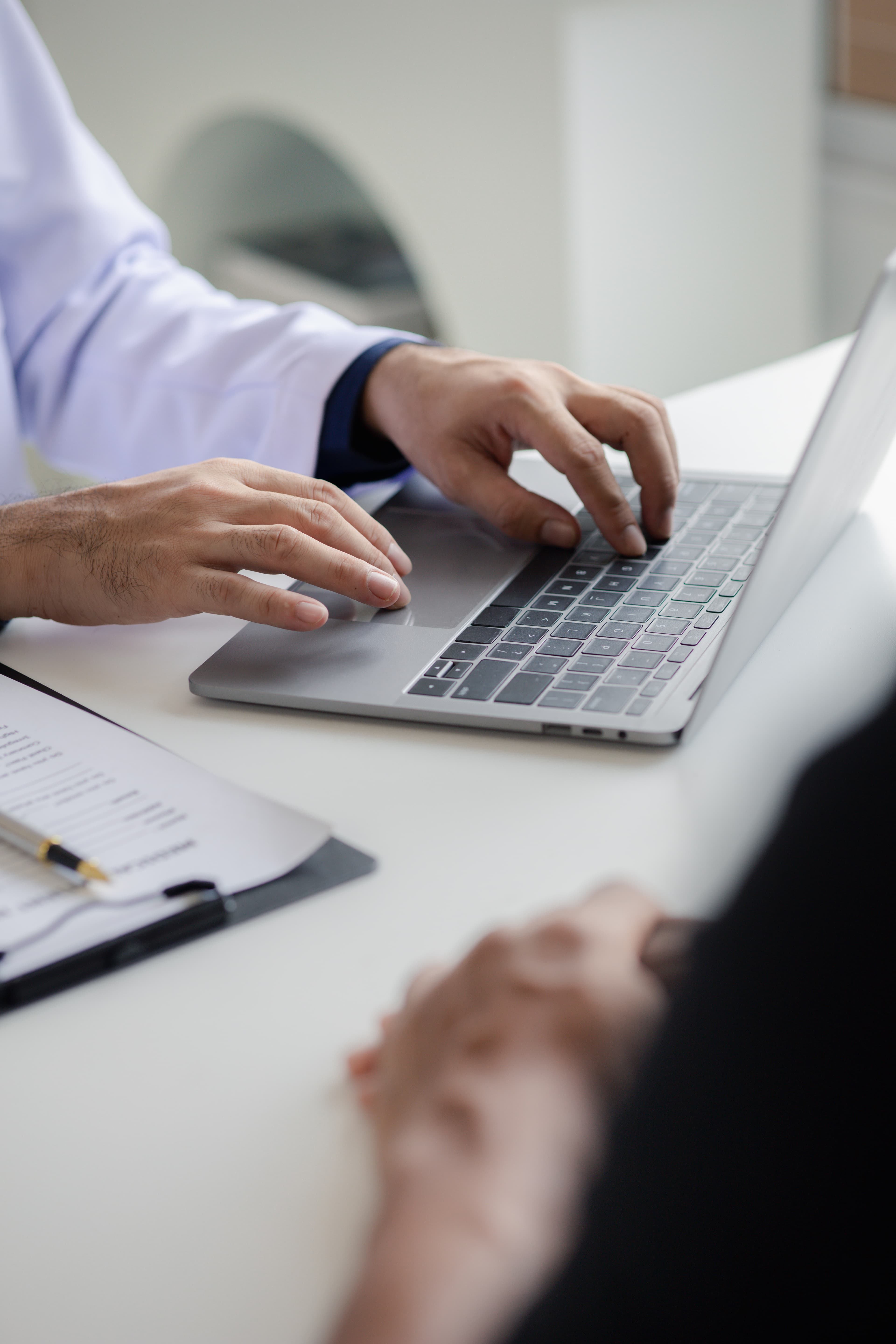 doctor typing on keyboard taking patient notes